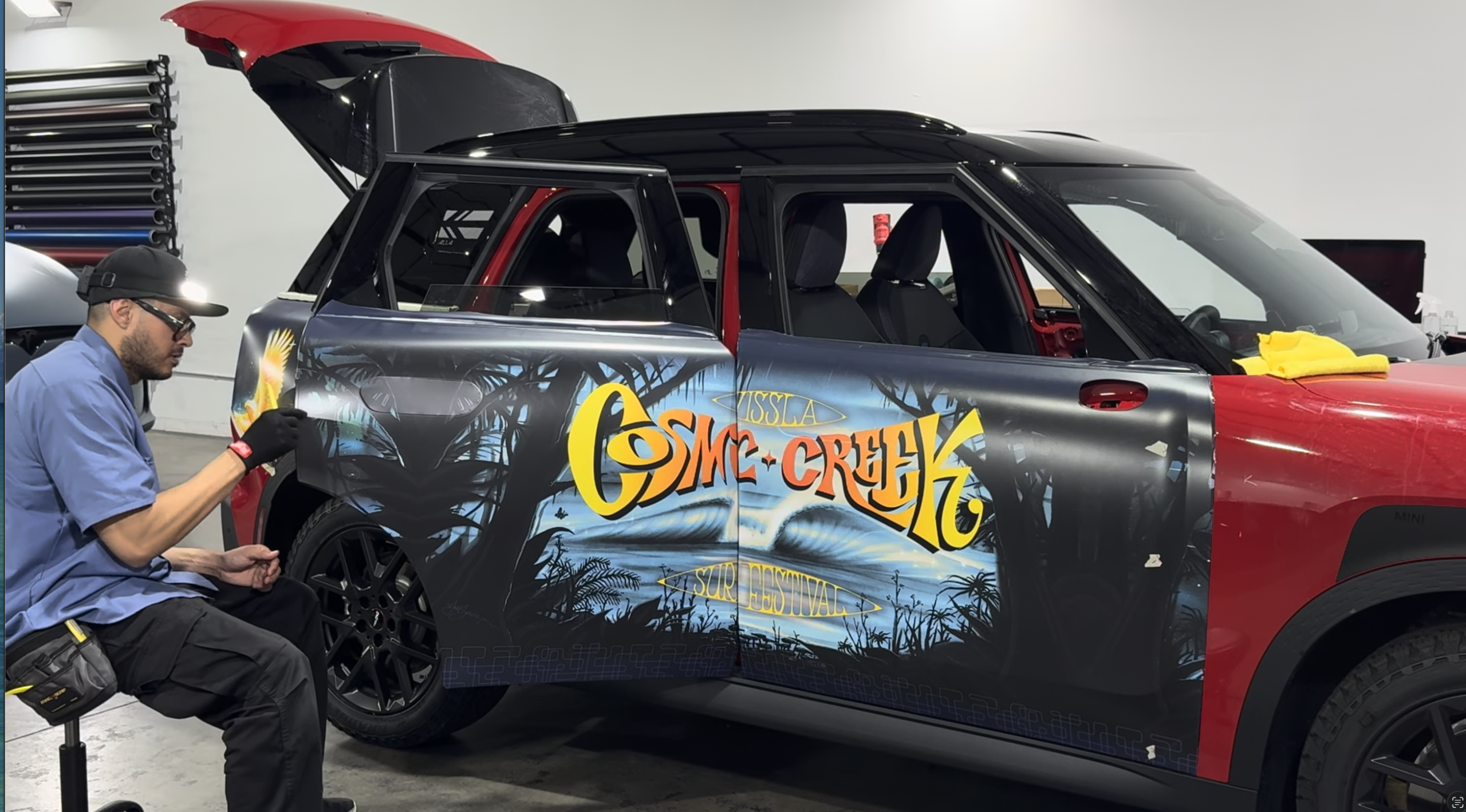 Experienced Wrap Bullys technician installing a custom printed wrap on a Mini vehicle
